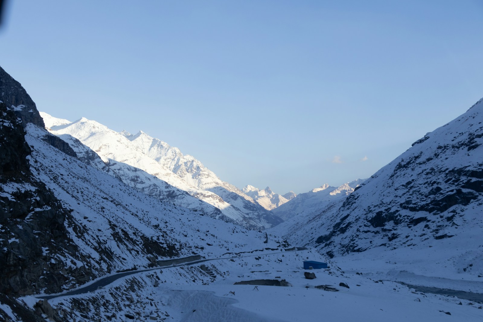A view of a snowy mountain road from a vehicle